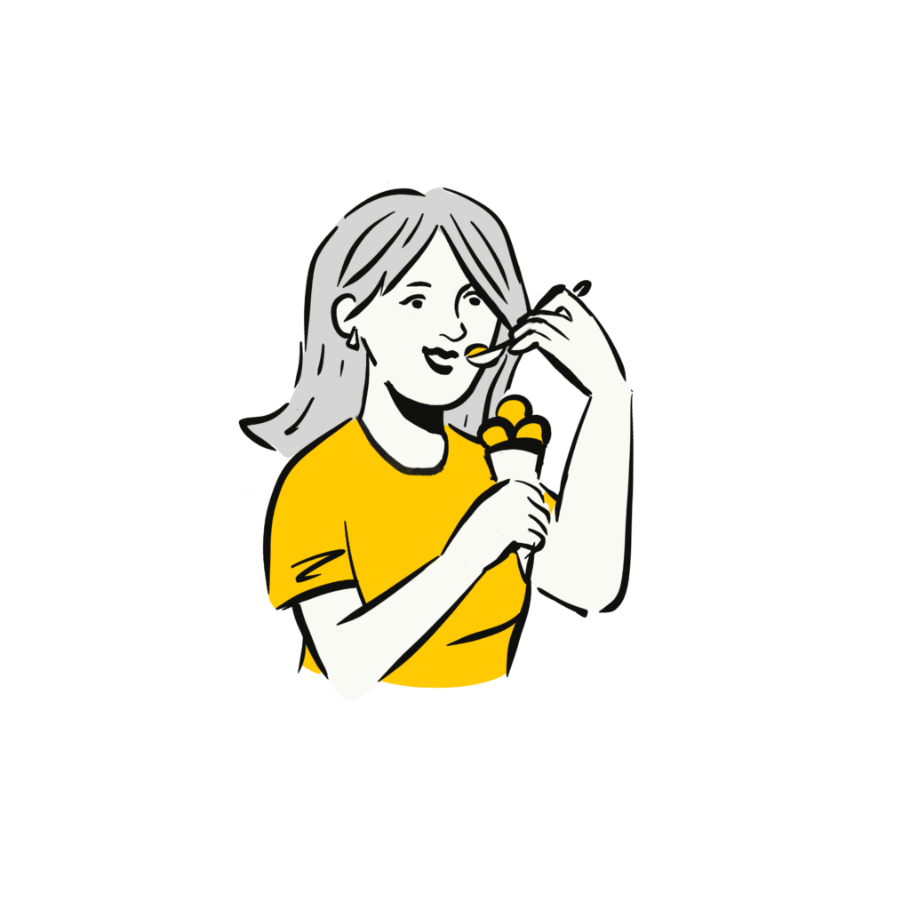 A person with shoulder-length hair and a yellow shirt eating ice cream from a cone with a spoon.