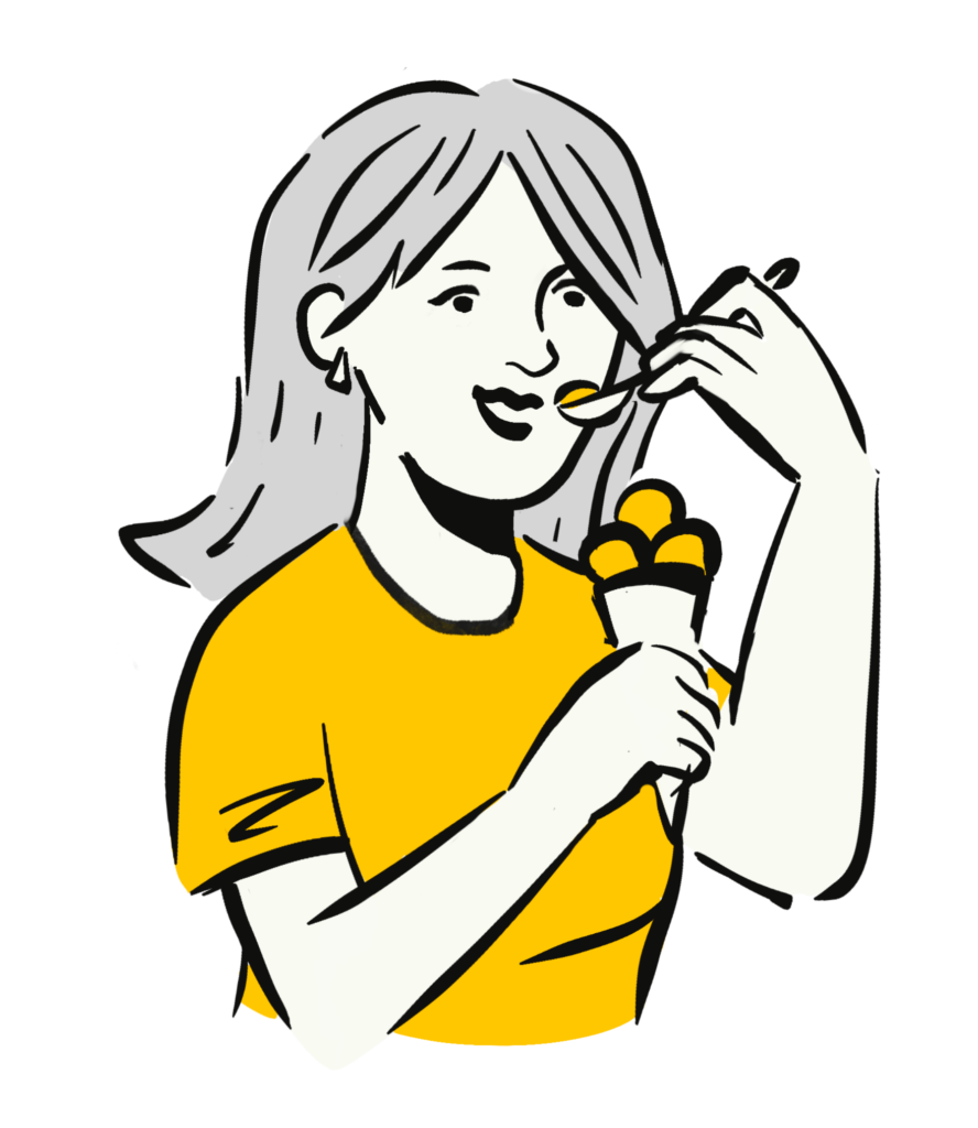 A person with medium-length hair is eating ice cream from a cone with a spoon. They are wearing a yellow shirt and smiling.